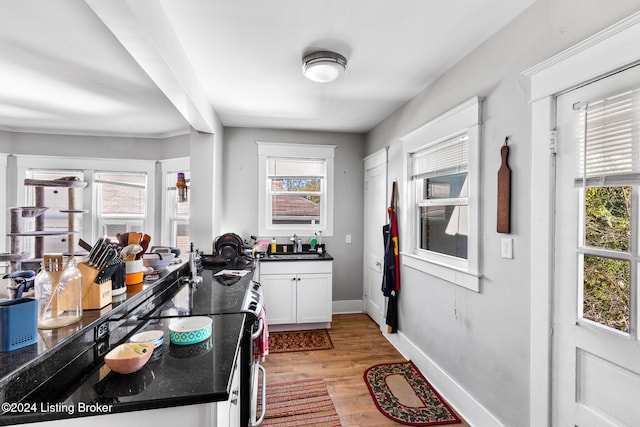 kitchen with white cabinets, a healthy amount of sunlight, and light wood-type flooring