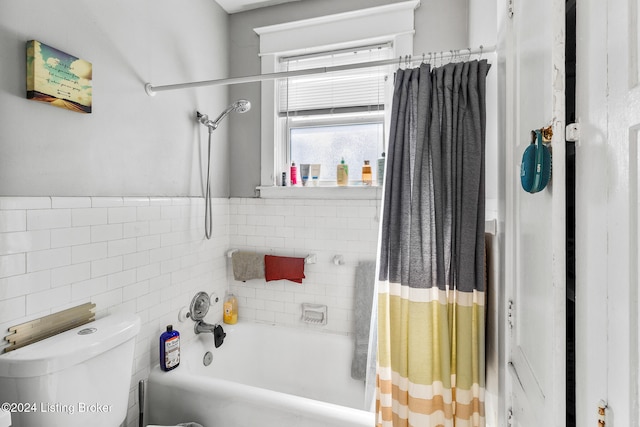 bathroom featuring toilet, shower / bath combination with curtain, and tile walls