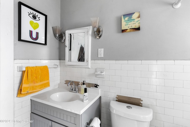 bathroom featuring tile walls, vanity, and toilet