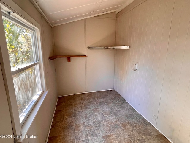 clothes washing area with wood walls