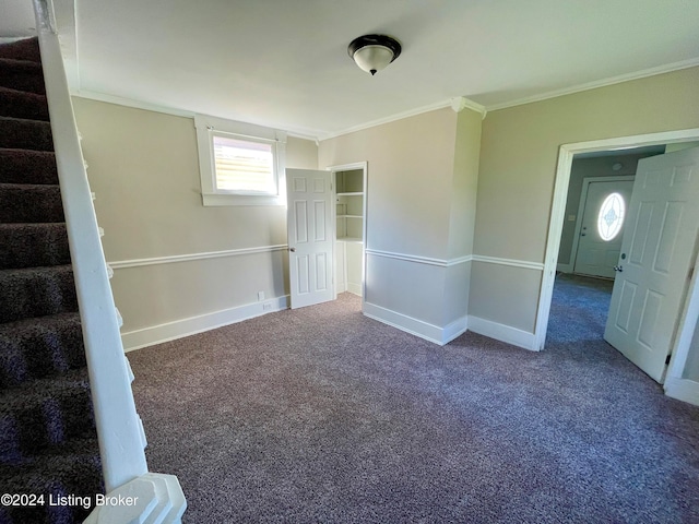 carpeted spare room featuring crown molding