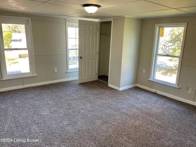 unfurnished room featuring carpet and plenty of natural light