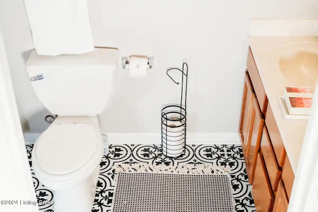 bathroom with toilet, vanity, and tile patterned floors