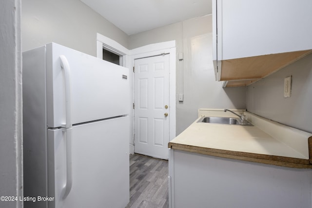 kitchen with white fridge, light wood-type flooring, and sink