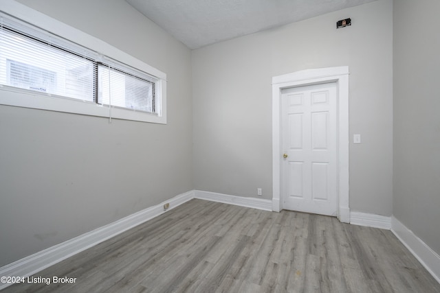 spare room featuring light hardwood / wood-style floors and a textured ceiling