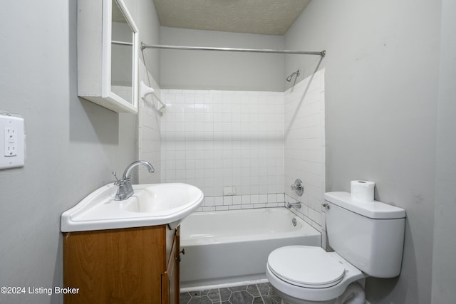 full bathroom featuring toilet, tiled shower / bath combo, vanity, and a textured ceiling