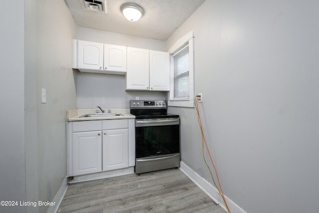 kitchen featuring sink, a textured ceiling, stainless steel range with electric stovetop, light hardwood / wood-style flooring, and white cabinets