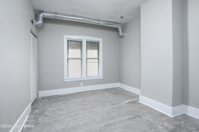 empty room with concrete flooring and a textured ceiling