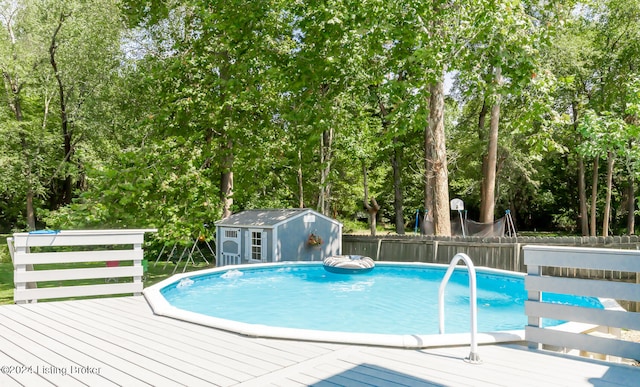 view of pool featuring a shed and a wooden deck