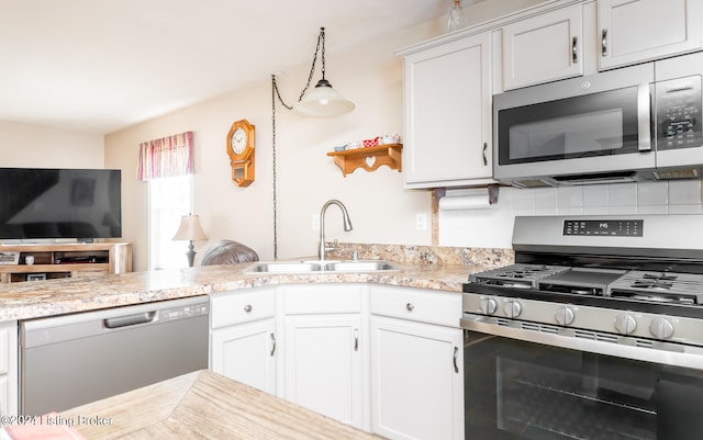 kitchen featuring tasteful backsplash, appliances with stainless steel finishes, sink, pendant lighting, and white cabinets