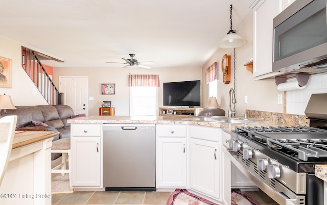 kitchen with white cabinetry, stainless steel appliances, sink, and pendant lighting