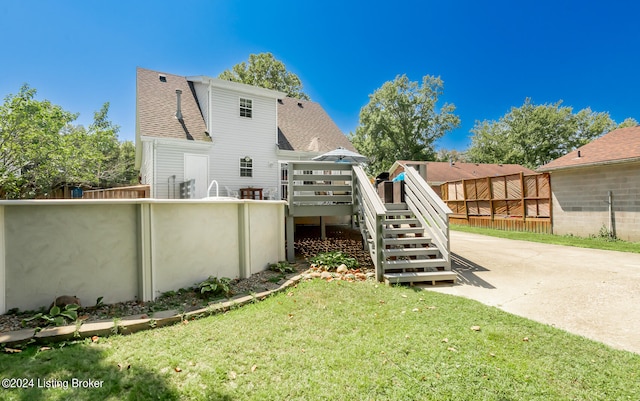 rear view of property featuring a yard and a deck