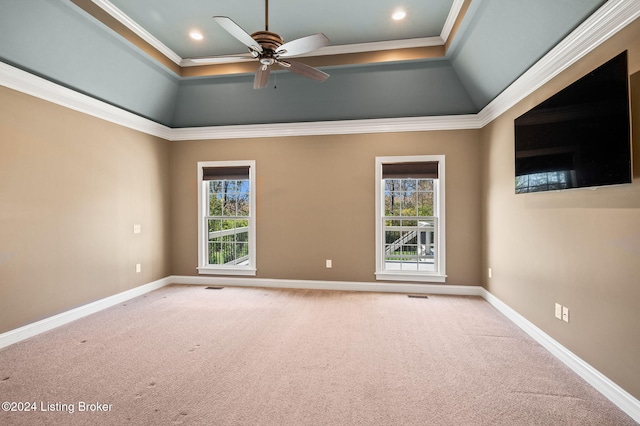 carpeted empty room with ceiling fan, plenty of natural light, and crown molding