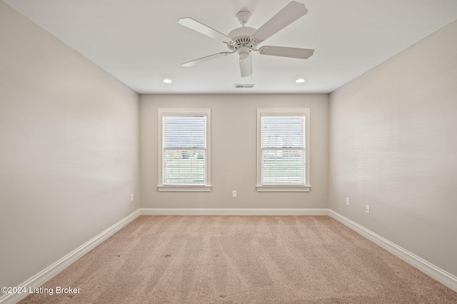 carpeted spare room with ceiling fan