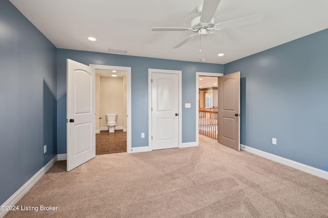 unfurnished bedroom with light colored carpet, ceiling fan, and ensuite bath