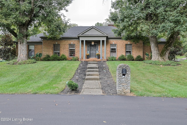 greek revival inspired property featuring a front lawn