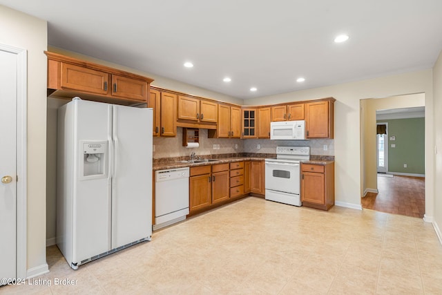 kitchen with white appliances, sink, backsplash, and light stone counters