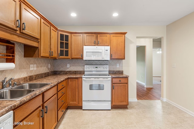 kitchen with backsplash, white appliances, and sink