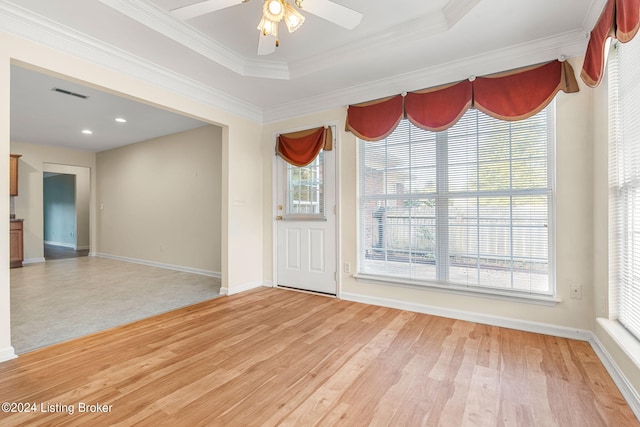 empty room with light hardwood / wood-style floors, ceiling fan, a healthy amount of sunlight, and crown molding