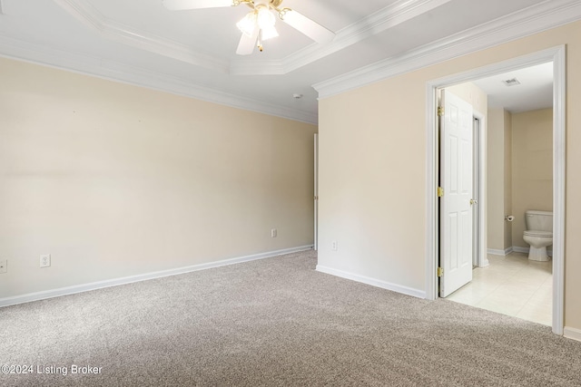 spare room featuring ornamental molding, light carpet, ceiling fan, and a tray ceiling