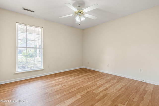 empty room with ceiling fan and light hardwood / wood-style flooring