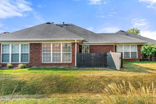 rear view of property featuring a lawn