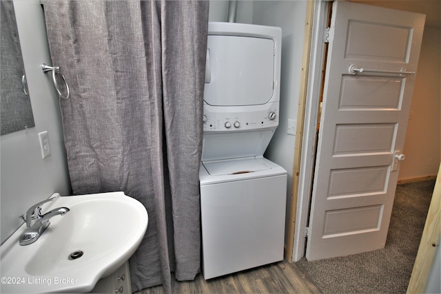 bathroom with stacked washer and dryer, vanity, and wood finished floors