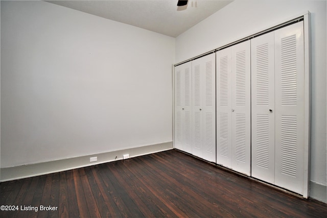 unfurnished bedroom featuring a closet, hardwood / wood-style flooring, and a ceiling fan