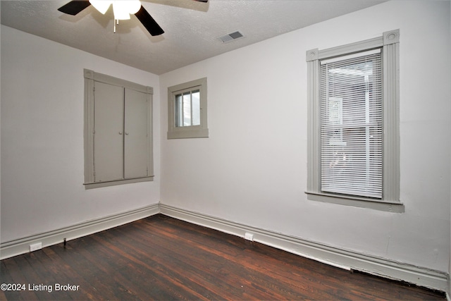 empty room featuring baseboards, visible vents, a ceiling fan, wood finished floors, and a textured ceiling