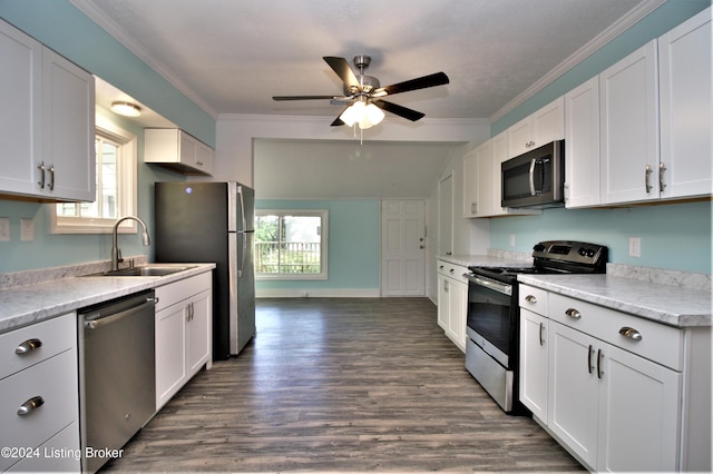 kitchen featuring stainless steel appliances, ornamental molding, a sink, and white cabinets