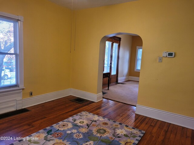 unfurnished room with dark wood-type flooring