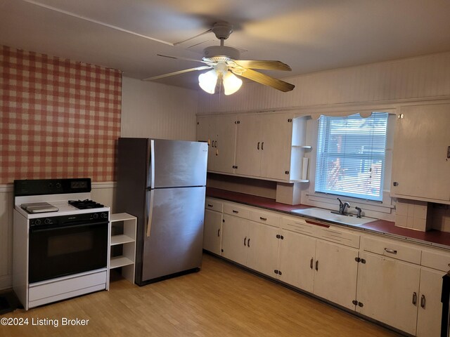 kitchen with stainless steel fridge, white cabinetry, ceiling fan, white range oven, and light hardwood / wood-style flooring