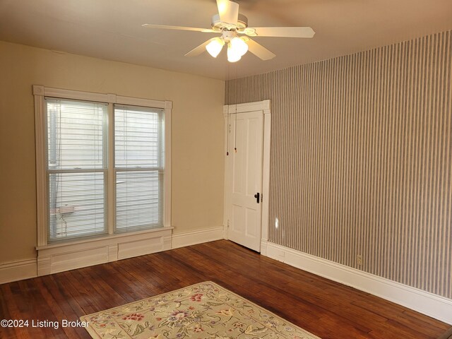 spare room with dark wood-type flooring and ceiling fan