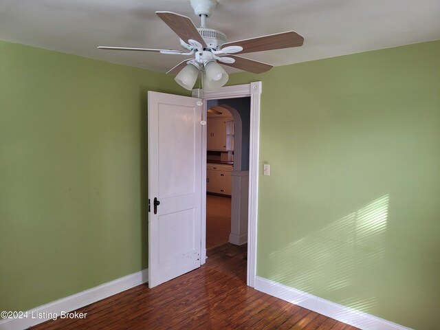 unfurnished room with ceiling fan and dark hardwood / wood-style flooring