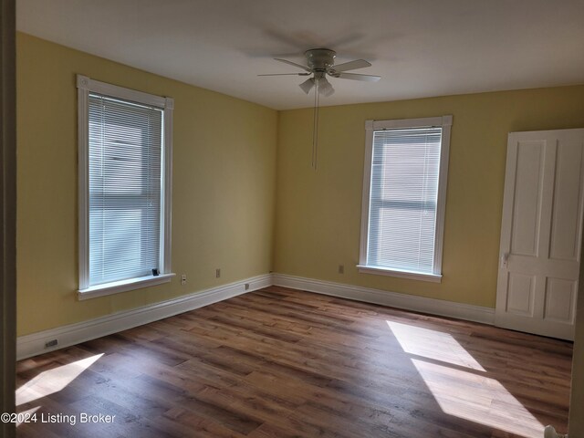 empty room with dark wood-type flooring and ceiling fan