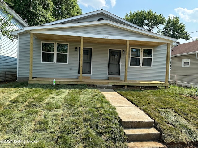 view of front of home featuring covered porch and a front lawn