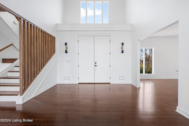 foyer entrance with a high ceiling and dark hardwood / wood-style floors