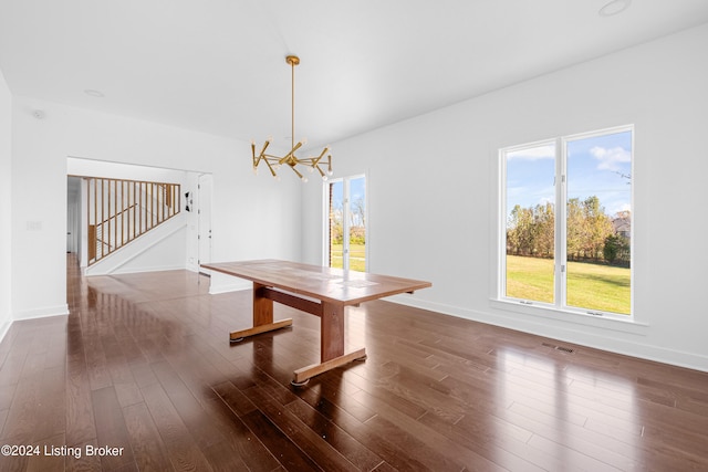 unfurnished dining area featuring dark hardwood / wood-style flooring and a notable chandelier