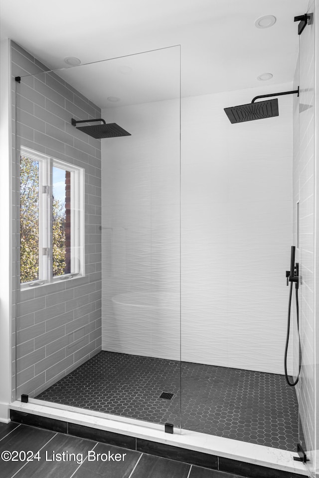 bathroom featuring tile patterned floors and a tile shower