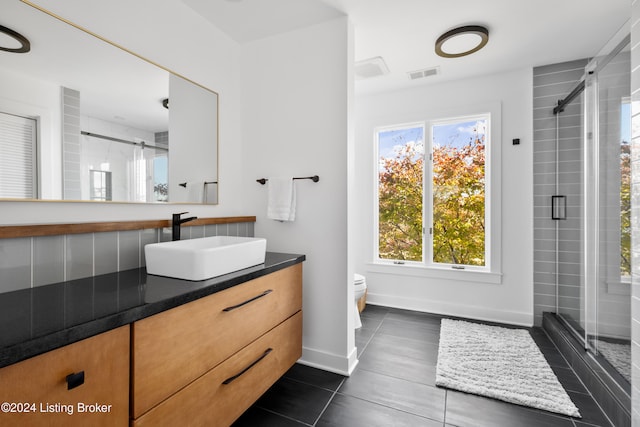 bathroom featuring vanity, walk in shower, tile patterned flooring, and toilet