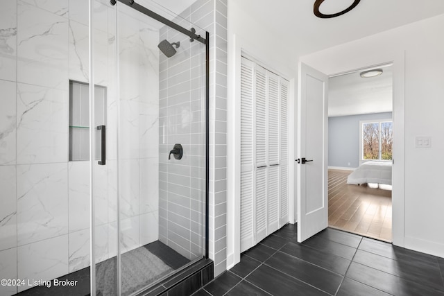 bathroom with hardwood / wood-style flooring and a shower with door