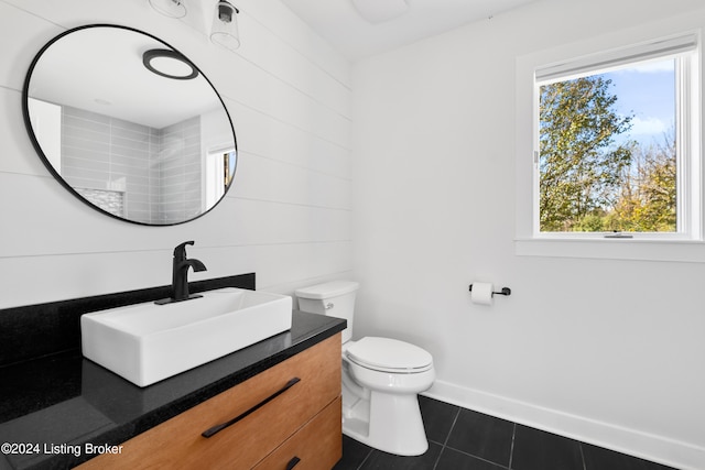 bathroom with toilet, vanity, and tile patterned floors