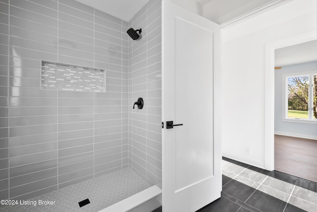 bathroom with tile patterned flooring and tiled shower