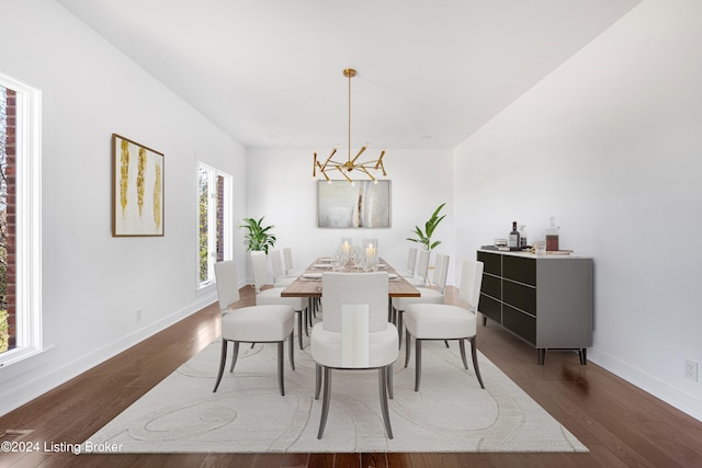 dining space featuring dark wood-type flooring and a chandelier