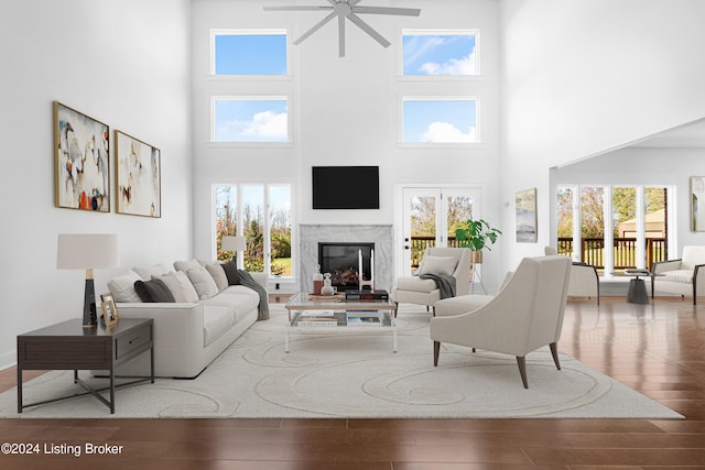 living room with hardwood / wood-style floors, a towering ceiling, and a wealth of natural light