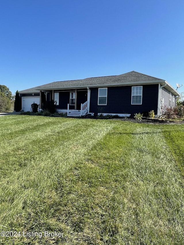 ranch-style home featuring covered porch, a garage, and a front lawn