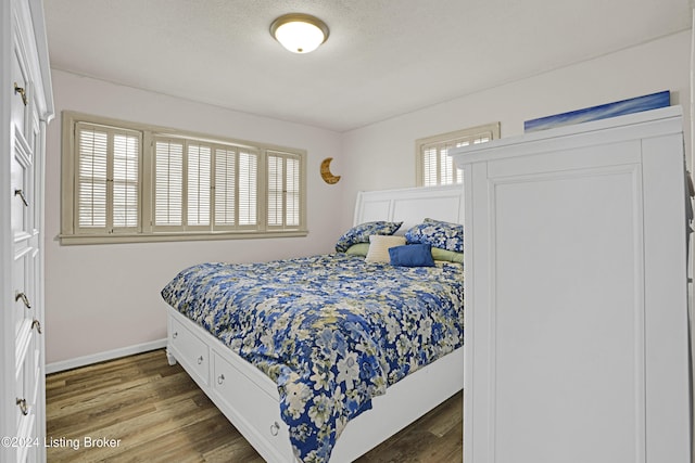 bedroom with baseboards and wood finished floors