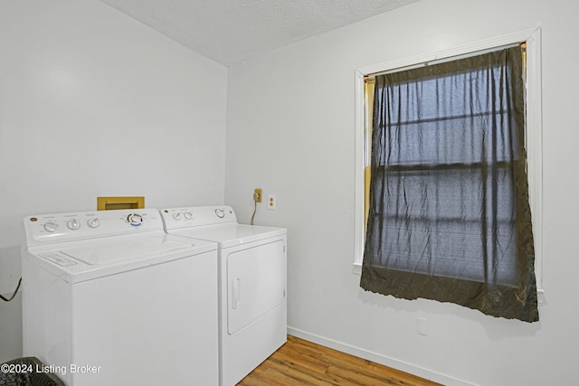 laundry room with wood finished floors, baseboards, laundry area, a textured ceiling, and independent washer and dryer