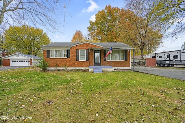 view of front of house featuring an outbuilding, brick siding, a detached garage, and a front yard