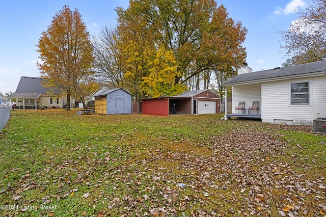 view of yard with an outdoor structure, fence, and a garage